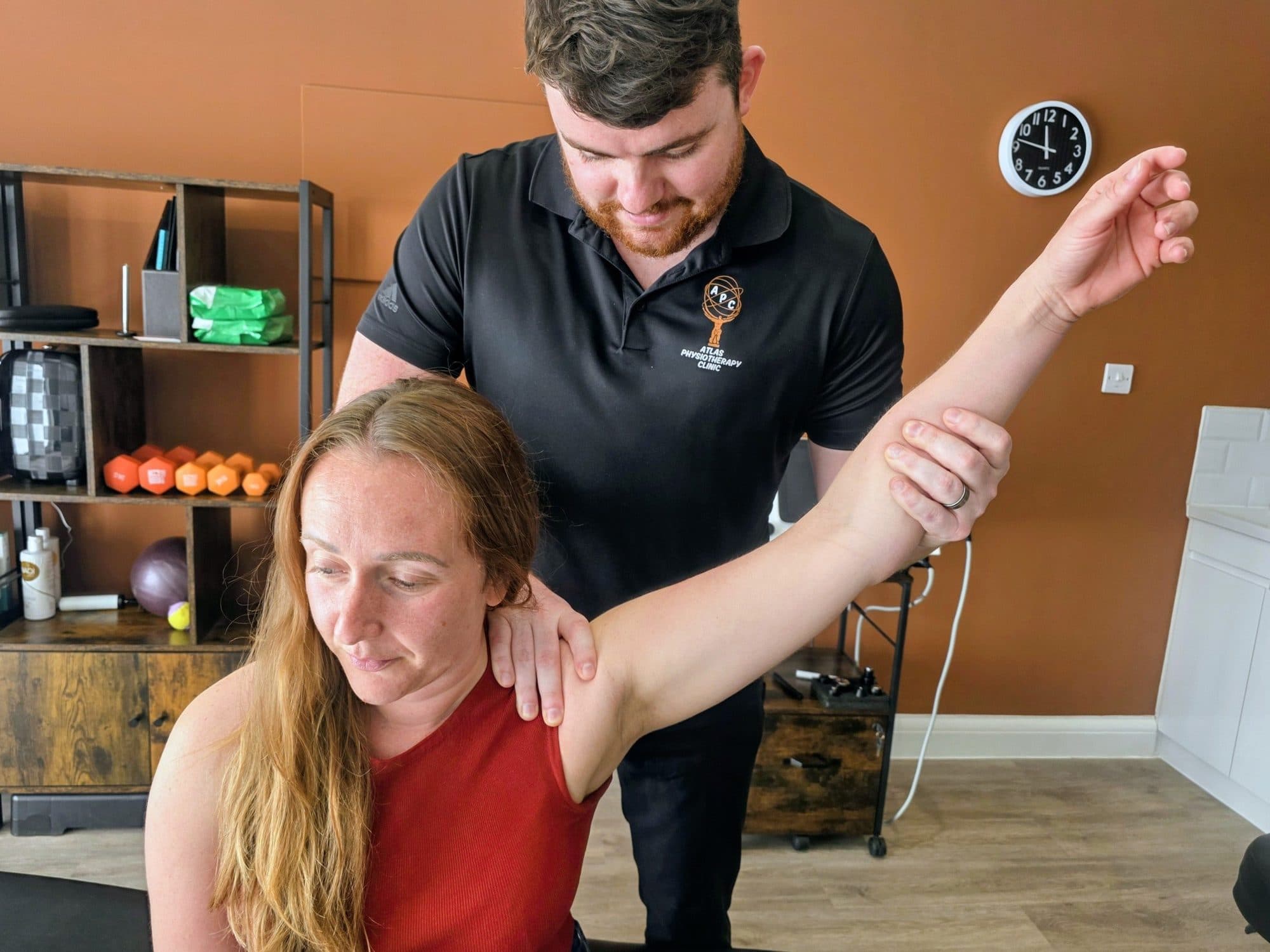 Connor assessing a patient's shoulder range of motion during a physiotherapy session