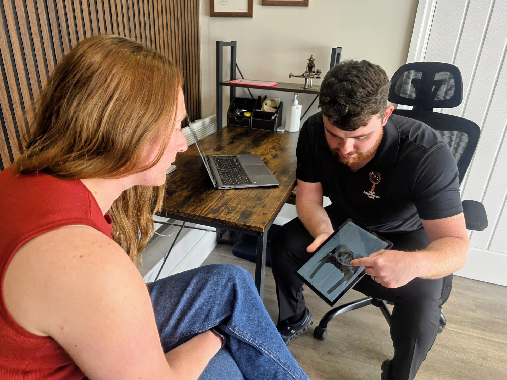 Connor reviewing imaging on a tablet with a patient during an injection therapy consultation
